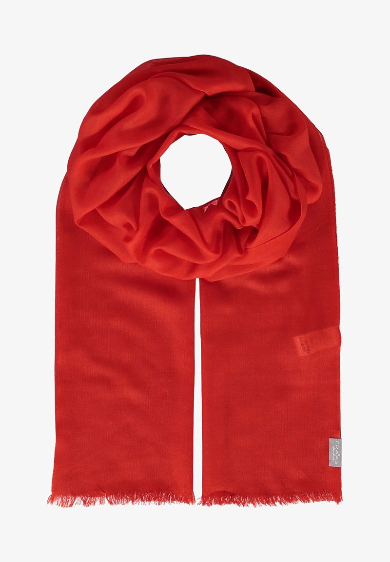 Écharpe en tissu doux rouge vif avec des bords effrangés et une petite étiquette de marque dans un coin, soigneusement pliée en boucle.
