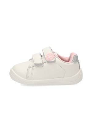 Zapatilla blanca infantil con forro rosa, dos tiras de velcro que incluyen un logo circular rosa y un detalle de talón con purpurina plateada.