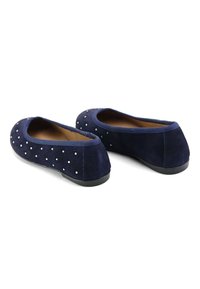 Bailarinas de ante azul marino con tacón plano, ribete elástico y adornos decorativos de tachuelas plateadas en la parte superior. Superficie texturizada con interior suave.