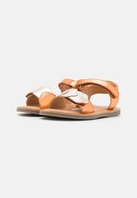 Le ciabatte in pelle arancione presentano un design floreale metallici argento sulle cinghie, con punta aperta e suola piatta. Inclusa una soletta testurizzata.