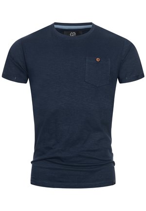 Sötétkék, rövid ujjú póló, textúrált anyagból készült, elöl egy zsebbel és a mellkason egy kis kör alakú logóval. A gallér belső részén vízszintes csíkok találhatók.