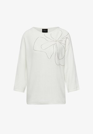 Haut blanc à manches longues avec une coupe ample. Présente une texture lisse et un motif floral décoratif en fil argenté sur le devant.