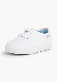 Sneaker bianco in tela per bambini con superficie testurizzata, punta rotonda, suola piatta in gomma e interno con motivo. Stringhe e piccolo dettaglio del logo.