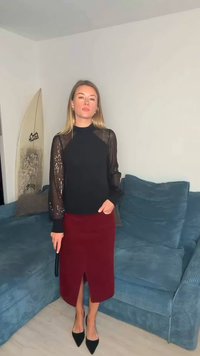 Long-sleeve black top with sheer sequin-embellished sleeves, paired with a fitted burgundy skirt featuring a front slit. Black pointed-toe heels.
