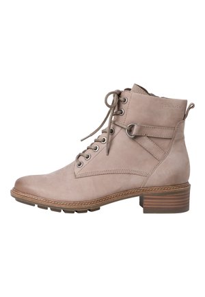 Beige læderankelstøvle med snørelukke foran, rund tå og 4 cm blokhæl. Har dekorative syninger og metalliske nitter.