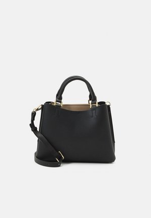 Sac à main en cuir noir avec deux poignées, une bandoulière amovible et des ferrures dorées sur un fond clair.