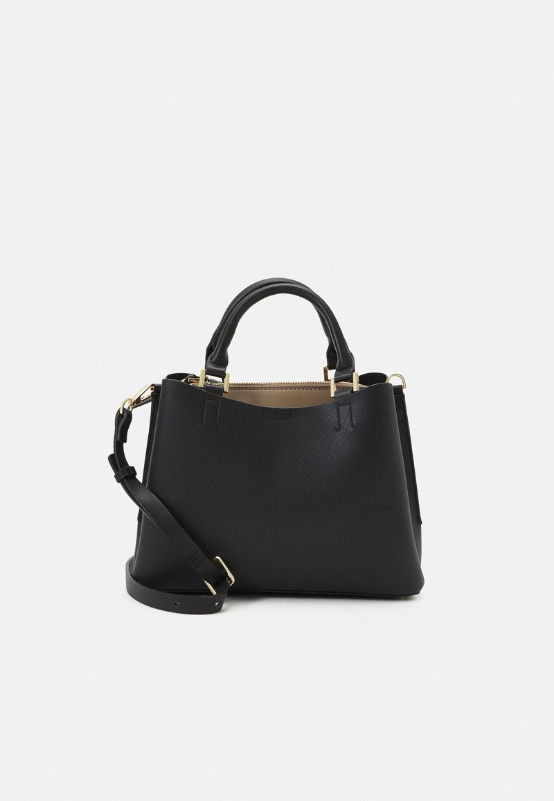 Sac à main en cuir noir avec deux poignées, une bandoulière amovible et des ferrures dorées sur un fond clair.