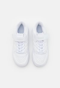 Sneakers bianchi con tomaia in pelle liscia, dettagli perforati, colletto imbottito e una chiusura in Velcro sopra i lacci tradizionali.