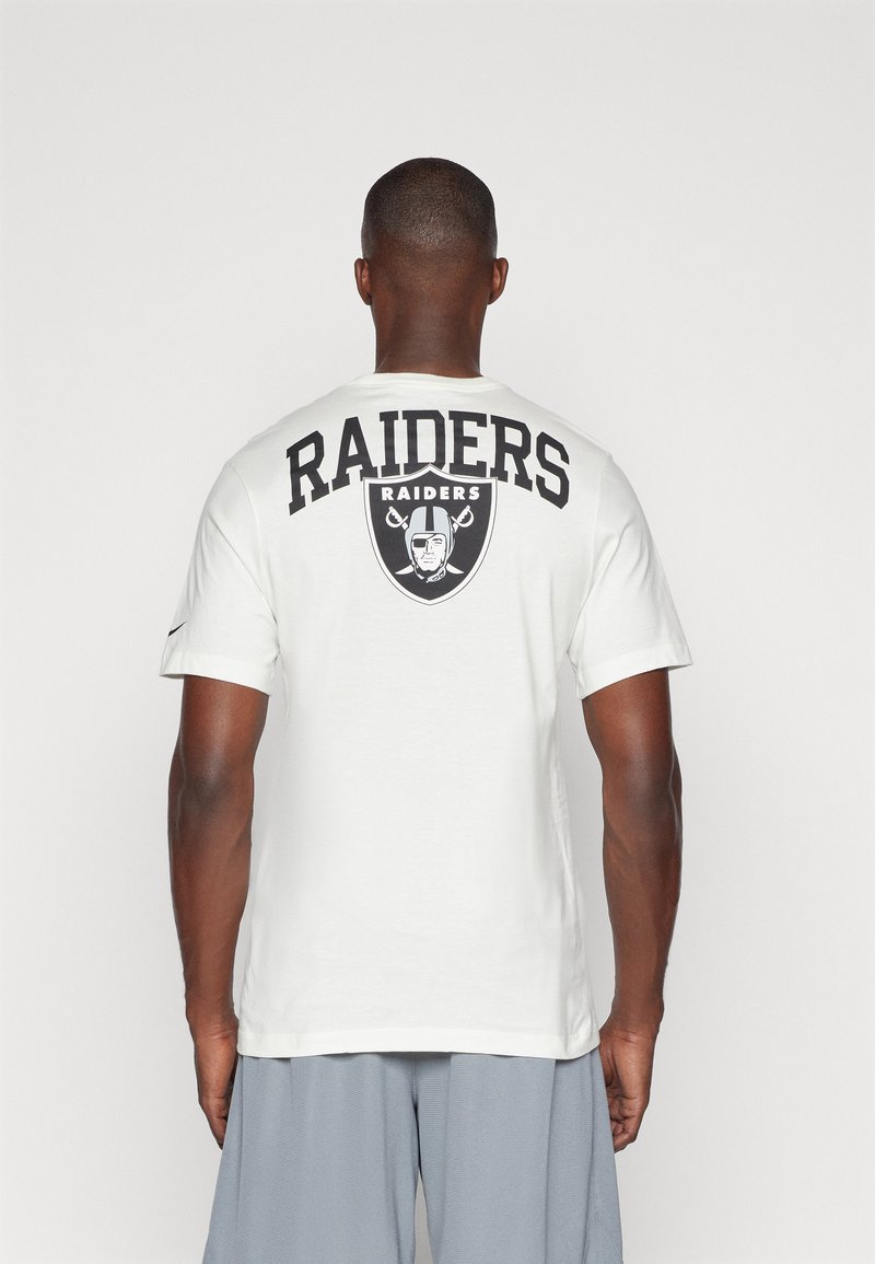 Camiseta de algodón blanca con un gran texto y logo en negro de "RAIDERS" en la parte posterior. Manga corta y cuello redondo.