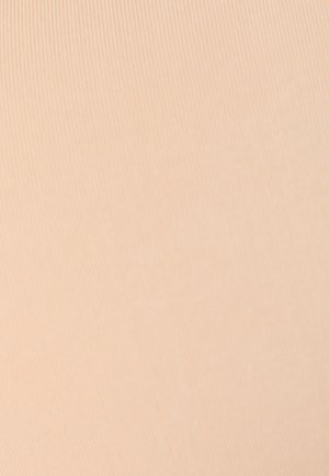 Una donna in kayak che pagaia su un lago calmo davanti a una foresta sotto un cielo limpido.