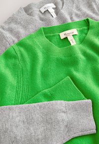 Pulls en maille verts et gris pliés avec cols ras du cou et poignets côtelés, avec étiquettes N. Premium Collection.