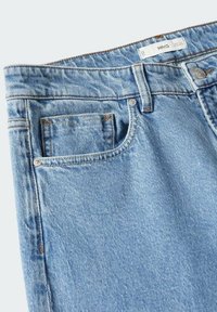 Vaqueros de mezclilla azul claro con un diseño clásico de cinco bolsillos, con costuras en cobre, cierre de botón y una etiqueta de la marca en la cintura.