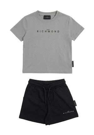 T-shirt grigia a maniche corte con scritta "JOHN RICHMOND" abbinata a pantaloncini neri con vita elastica, entrambi con etichette del marchio ai lati.