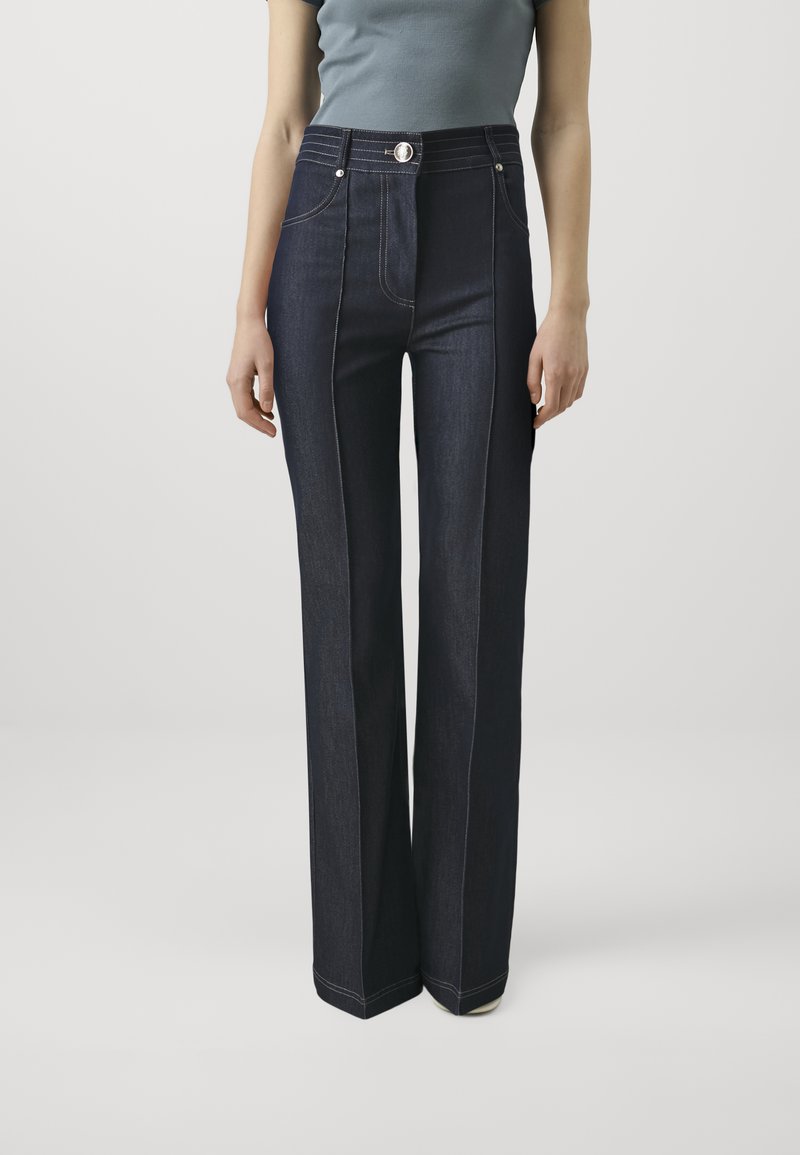 Jeans in denim scuro a vita alta con design a gamba dritta, dotati di cuciture a contrasto, chiusura con bottone e tasche frontali.