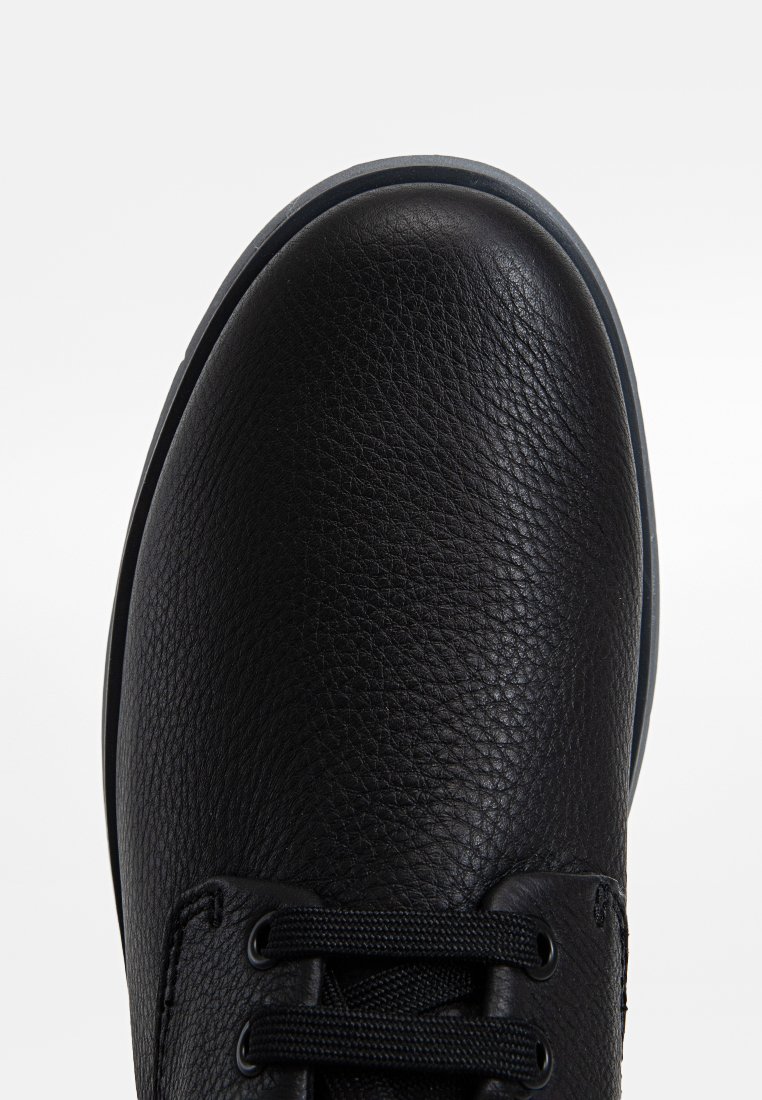 Czarne skórzane sneakersy z fakturowaną powierzchnią, okrągłym czubkiem i czarnymi sznurówkami. Posiadają gumową podeszwę oraz subtelne szare akcenty wokół krawędzi.