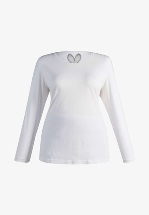 Ilgų rankovių balta marškinė suapvalintu iškirpimu, pagaminta iš medvilnės, su širdelės formos mezginiu nugarinėje pusėje. Sklandi tekstūra.