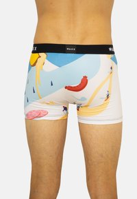 Boxers avec une ceinture noire portant la marque "WAXX." Design coloré avec des éléments alimentaires et des figures stylisées sur un fond clair.