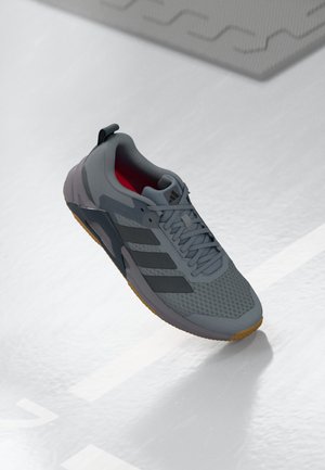 Gray athletic shoe with mesh upper, rubber sole, and black lateral stripes. Features a red interior and a reinforced heel tab.