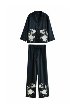 Conjunto din două piese format dintr-o bluză navy închis și pantaloni asortați. Bluza are broderie florală albă pe buzunare; pantalonii au detalii asortate.