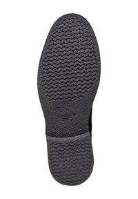 Suola di scarpa in gomma nera con motivo ondulato strutturato, con il logo "GEOX" vicino al tallone. Superficie liscia con leggera curvatura.