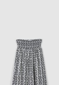 Abito a strisce bianche e nere con top arricciato, tessuto fluido e un design a forma di foglia su tutta la gonna.