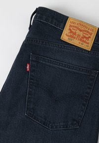 Σκούρο μπλε πίσω τσέπη τζιν Levi's με κόκκινη ετικέτα Levi's και ταμπέλα δέρματος σε ταμπά με μέγεθος W32 L32 και μοντέλο 515.