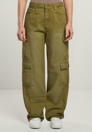 Pantalons cargo vert olive à jambes larges, avec plusieurs poches et une texture lisse. Dotés d'une fermeture à bouton et de passants de ceinture, associés à des baskets blanches.