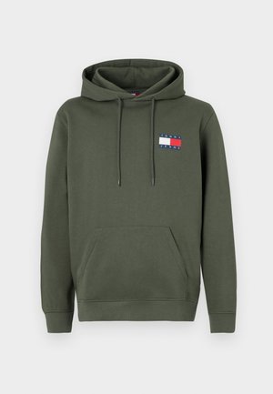 Olive green hoodie with a front pocket, adjustable drawstring hood, and a small multi-colored logo patch on the chest. Soft fabric texture.