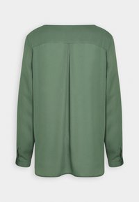 Camicia a maniche lunghe in tessuto verde oliva con una texture liscia, caratterizzata da un taglio dritto, pinces sul retro e aperture sui polsini con bottone.
