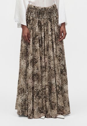 Lang plisseret nederdel med brun og beige dyreprint, båret med hvid bluse og hvide spidse sko.