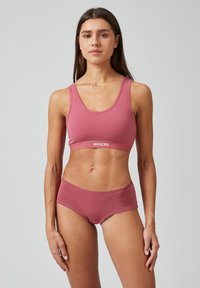 Roze katoenen sportbeha met een brede band met het "SNOCKS" logo. Gecombineerd met bijpassende hipsteronderbroek, beide hebben een zachte textuur.