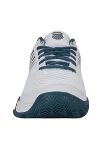K-Swiss tenisa apavi ar baltu virsmas daļu, kurai ir teksturētas līnijas, teal krāsas šņorēm un gumijas zoli ar zigzaga profilēšanu. Logo uz mēles.
