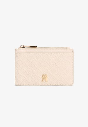 Kaarthouder van crèmeleer met geperst patroon, logo van goudkleurig metaal en bovenste ritssluiting, getoond tegen een witte achtergrond.