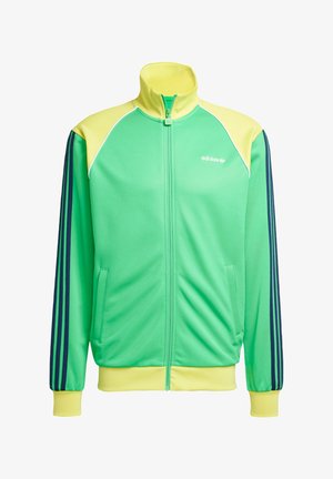 Casaco desportivo com fecho éclair verde e amarelo, gola alta, dois bolsos frontais, riscas azuis nas mangas e logótipo bordado no peito.