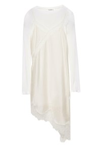 Bela majica z dolgimi rokavi, plast nad asimetrično kremno obleko za prekrivanje s čipkastim robom na spodnjem delu.