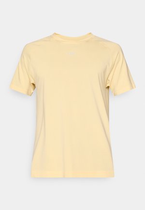 Vaaleankeltainen lyhythihainen t-paita pyöreällä pääntiellä ja sileällä pinnalla. Mallissa on raglansuut ja etupuolella hillitty logo.