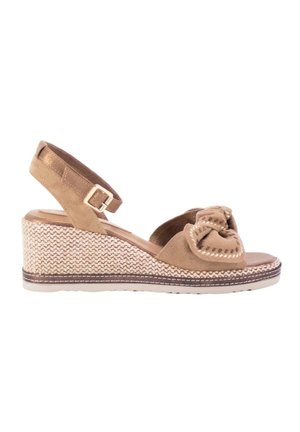 Sandalia de cuña beige con tira al tobillo, tacón con textura tejida y detalle de lazo anudado en la parte delantera de puntera abierta.