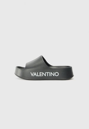 Sandal de slide preto feito de material suave com um design curvado. Apresenta uma tira larga e o logotipo em relevo "VALENTINO" em branco na lateral.