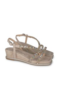 Sandali con zeppa beige dalla texture liscia, con cinturini incrociati decorati da strass multicolori e una suola leggermente glitterata.