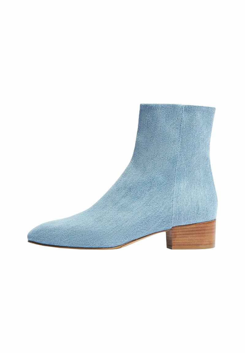 Botas de tobillo azul claro hechas de un tejido texturizado, con punta afilada y un bajo tacón de bloque de madera.