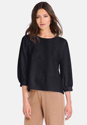 Blusa nera con scollo rotondo, maniche a tre quarti a sbuffo e vestibilità ampia. Tessuto liscio con dettagli arricciati ai polsini delle maniche.