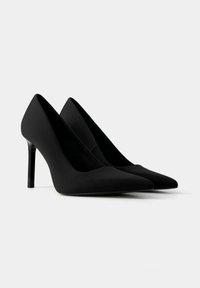 Black high-heeled pumps made of smooth material, featuring a pointed toe and a sleek, glossy heel, presented from the side view.