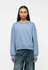 Ανοιχτό γαλάζιο sweatshirt με στρογγυλή λαιμόκοψη, ραμμένα μανίκια και στρίφωμα. Έχει το λογότυπο της Calvin Klein κεντημένο στο στήθος. Κατασκευασμένο από βαμβάκι.