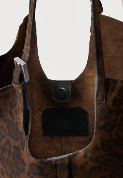 Sac à main en daim marron avec imprimé léopard, bandoulière en cuir avec boucle argentée et fermeture à bouton-pression noire à l'intérieur.