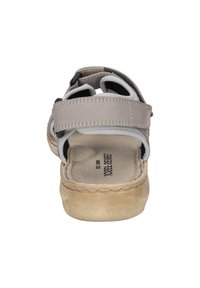 Lichtgrijze sandaal met meerdere verstelbare banden. Zachte suede-achtige zool, gevoerde inlegzool en contrasterende zwarte accenten. Casual ontwerp.