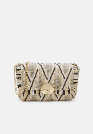 Petit sac bandoulière tissé avec motif chevron noir, blanc et beige, bordure à franges, bandoulière en chaîne dorée et fermeture à boucle ronde dorée.
