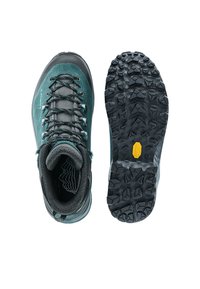 Πεζοπορικό μποτάκι σε τυρκουάζ και γκρι, εμφανιζόμενο από πάνω και από τη σόλα, με ανθεκτικό μαύρο πέλμα και λογότυπο Vibram για εξωτερική πρόσφυση.