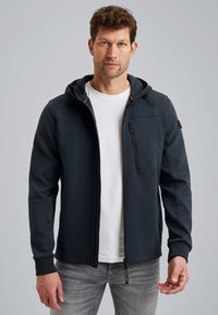 Mørkeblå zip-up hoodie med en glat tekstur, justerbar hætte og en frontlomme med lynlås, parret med en hvid t-shirt og grå jeans.