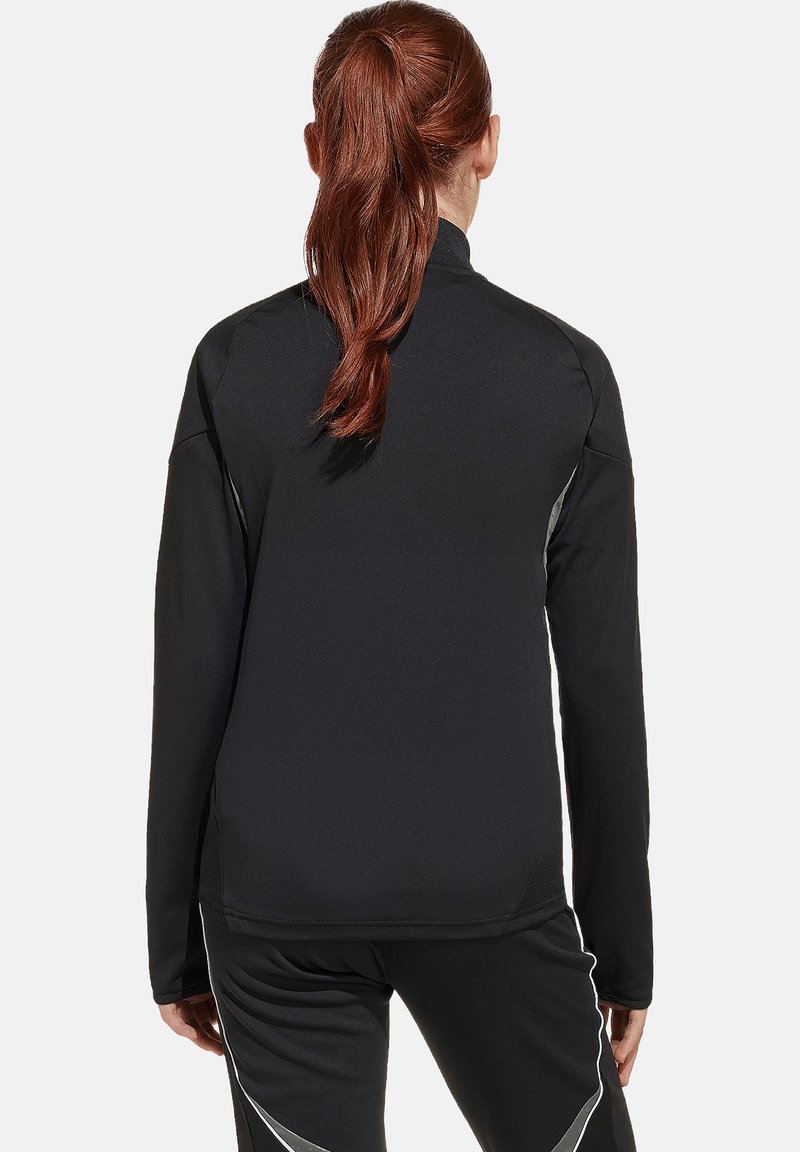 Zwarte sport fleece jas met lange mouwen, hoge kraag en reflecterende accenten langs de zijkanten. Zachte, gladde stoftextuur.