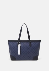 Sac fourre-tout bleu marine en tissu à motifs, avec une base unie, des accents noirs contrastés, deux poignées robustes et une étiquette blanche.